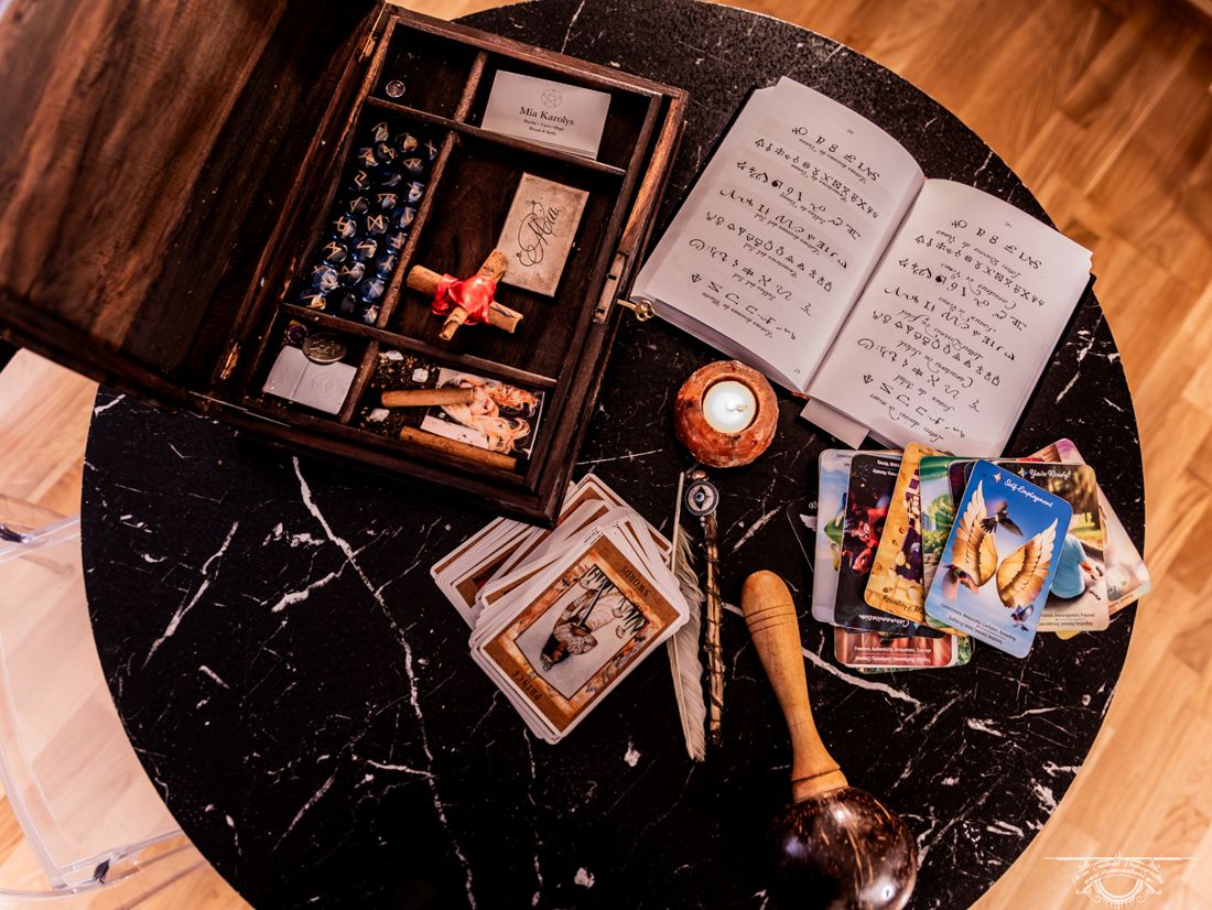 Ritual box, grimoire and oracle cards on a marble table